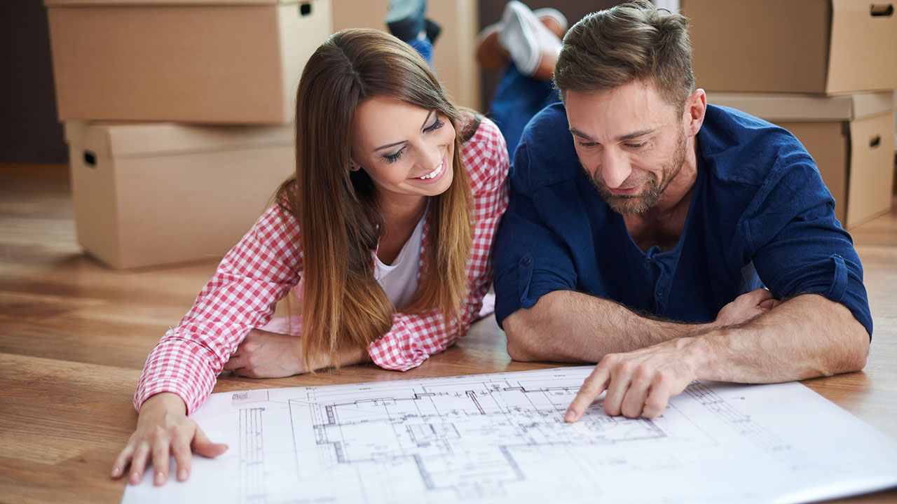 Pareja planificando la reforma de su vivienda con planos en el suelo, proyecto realizado por Reformas Néstor en Madrid y Toledo